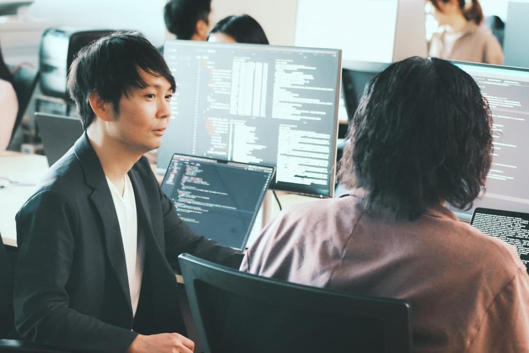 オフィスで同僚と会話している様子