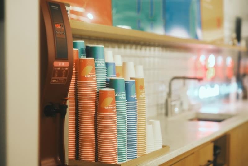 バリューの書かれた紙コップと飲み物ディスペンサー